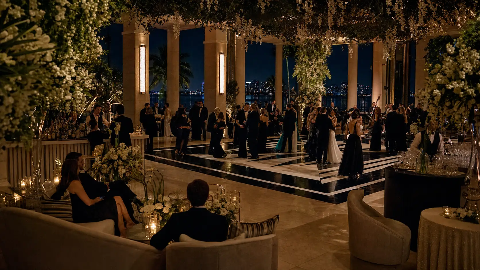Una pista de baile de boda de etiqueta enmarcada por flores blancas y luz de velas durante la noche